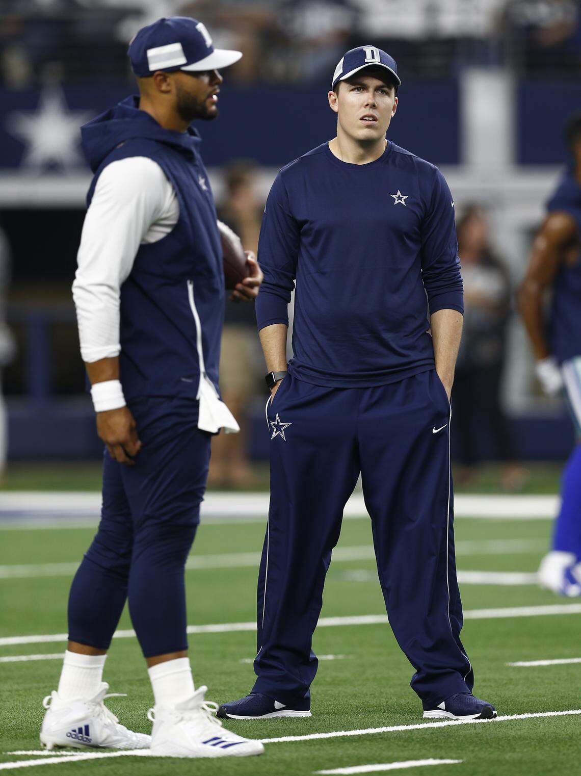 Dallas Cowboys quarterback coach Kellen Moore, right, talks with Dak Prescott during warmups before an NFL football game against the New York Giants on Sunday, Sept. 16, 2018, at AT&T Stadium in Arlington, Texas.