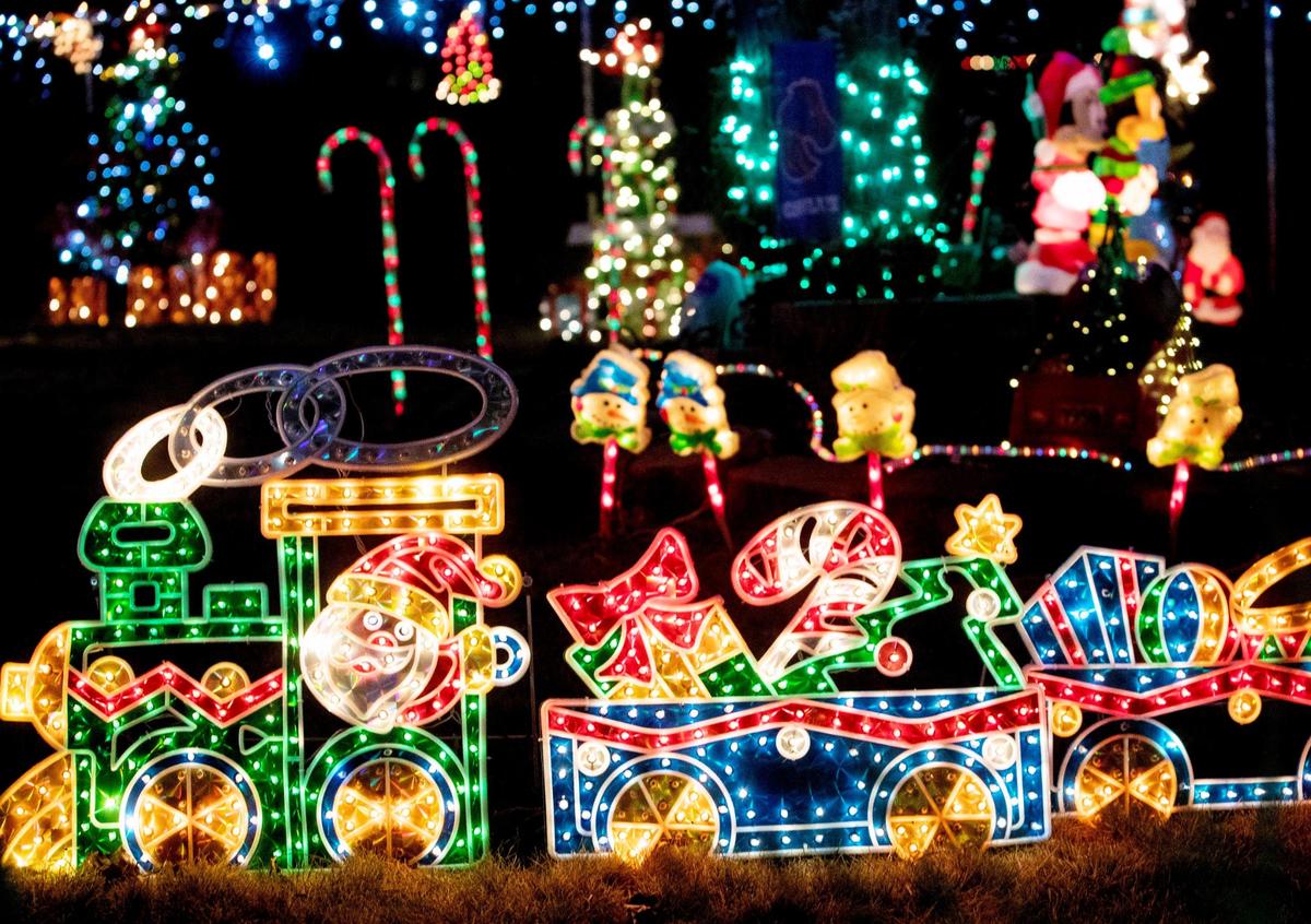 Santa in a train plus many more decorations glow with light in the from yard of a home on West Edna Street in Boise.