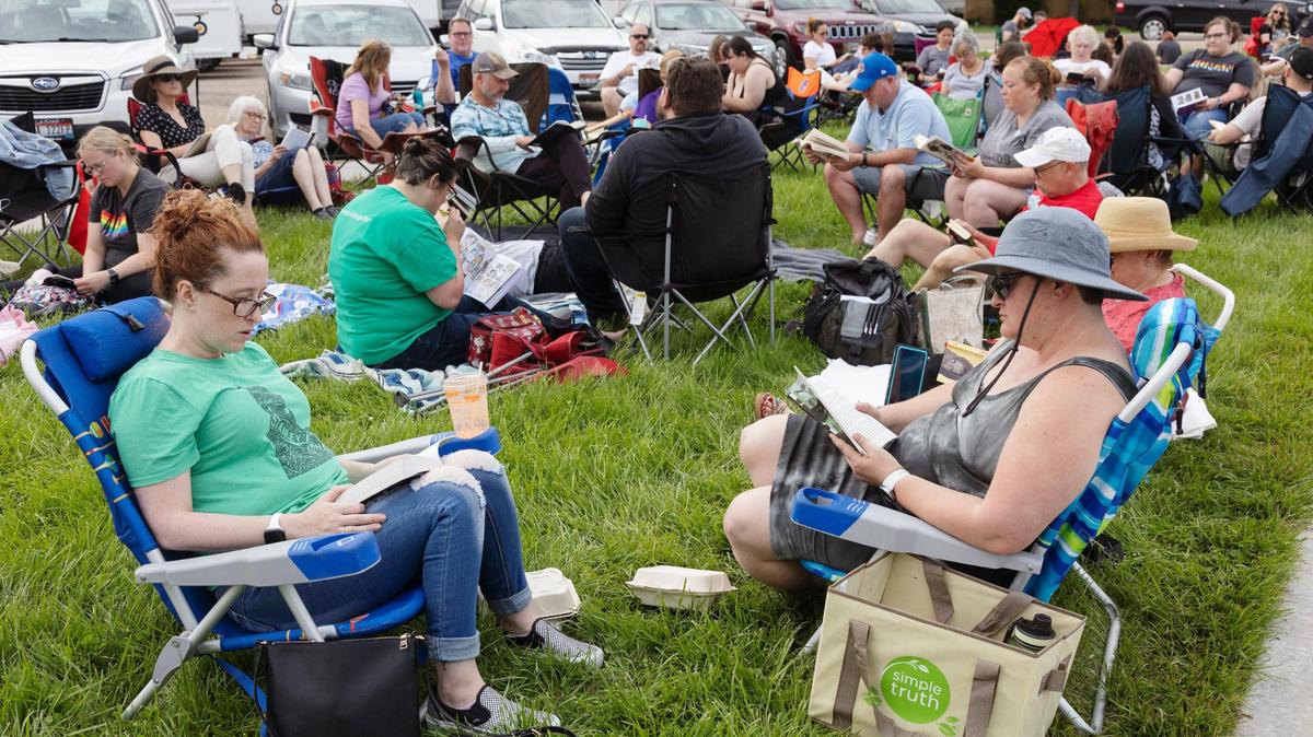 Dozens of people read banned books on the lawn of the Nampa School District office at the same time a meeting takes place inside to determine the disposal of books on its banned list.
