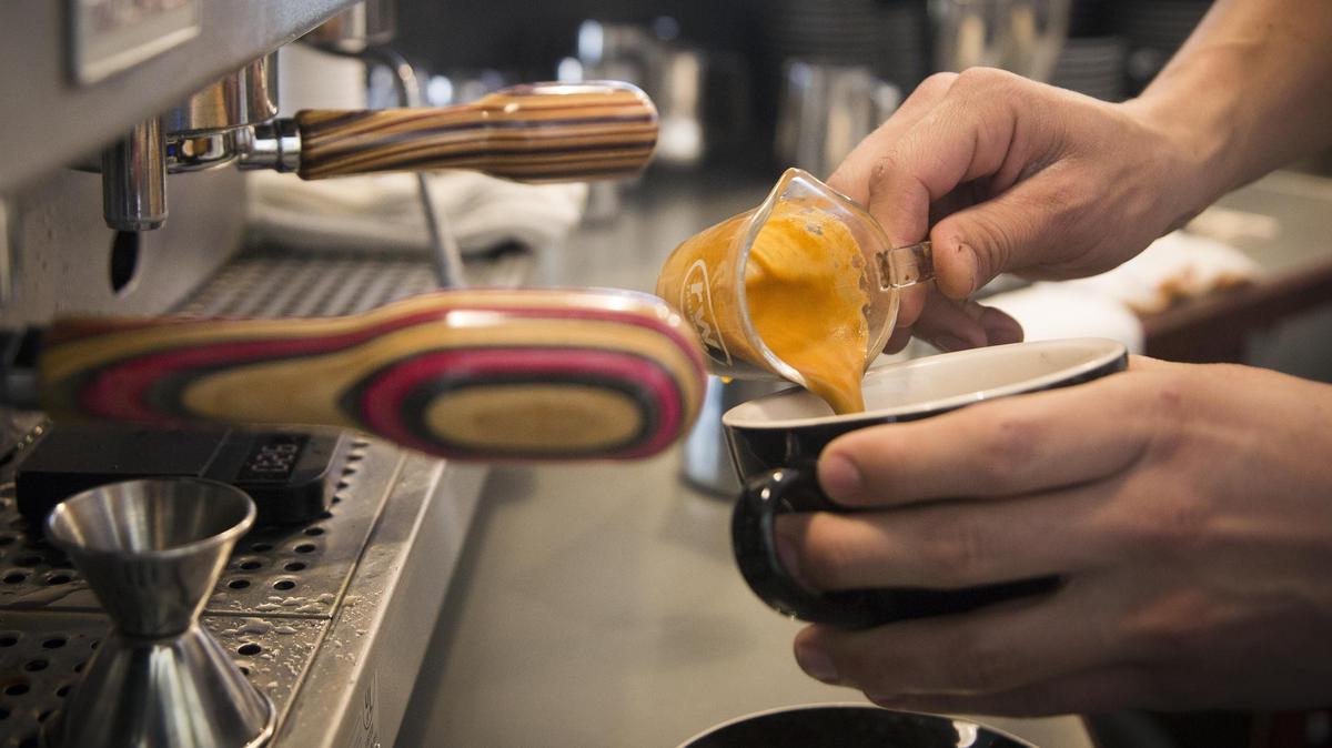 Push & Pour Coffee owner Lucas Erlebach whips up a latte on an espresso machine fitted with custom-crafted handles.