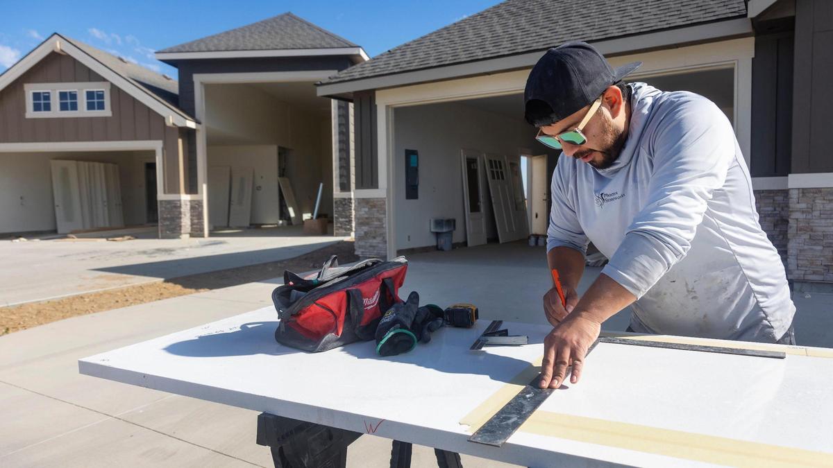 Manny Araujo, owner of Phoenix Stoneworks and contractor with Dale’s Flooring and Granite, takes measurements for a cooktop cutout for a new home by Sunrise Homes on Begonia Lane in Nampa on Tuesday.