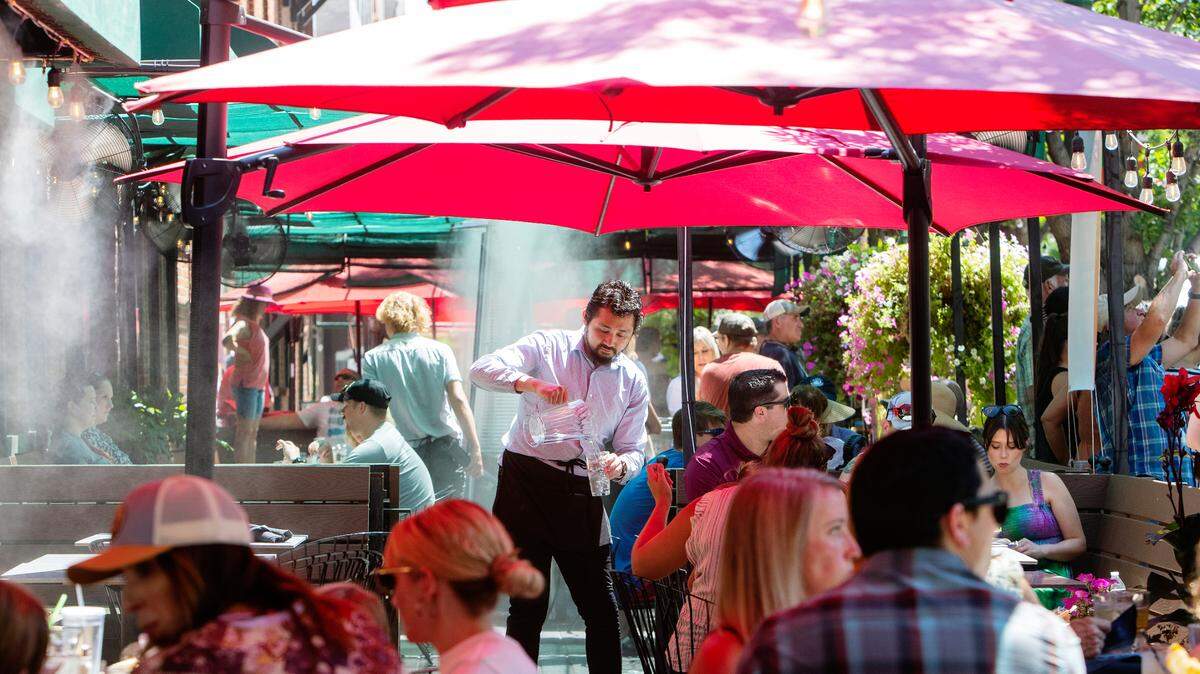 Waiter David Kan serves cold water to restaurant patrons on the patio of Bardenay in the Basque Block of downtown Boise on July 30, 2022. Temperatures above 100 degrees are expected over the weekend.