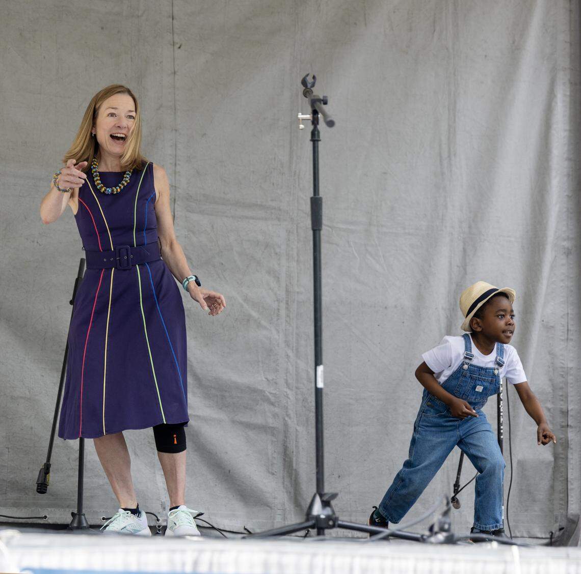 McLean dances with Jayden Kitamba, 5, whose family is from The Republic of the Congo, during a June celebration of World Refugee Day at Grove Plaza.