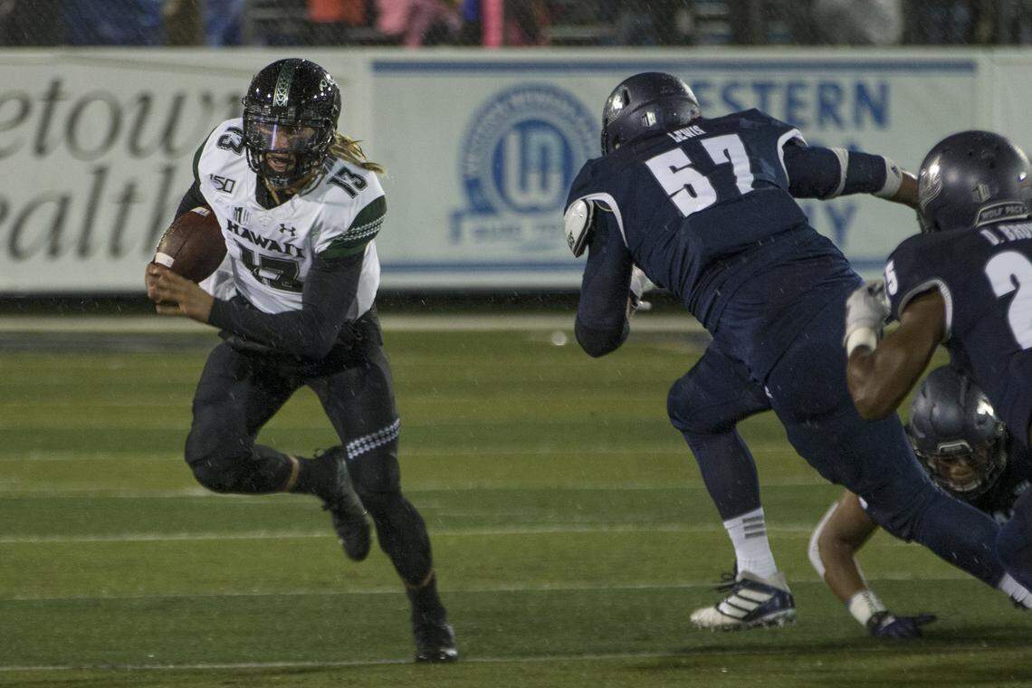 Hawaii quarterback Cole McDonald rolls out as he is rushed by Nevada defensive end Jaden Lewis earlier this season.