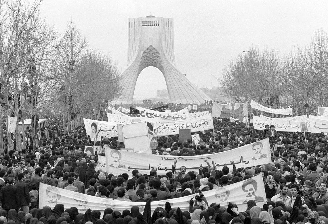 Iranians climb trees to watch a demonstration in Tehran in support of Ayatollah Ruhollah Khomeini during the Iran Revolution of 1979. In background is the Azadi Tower, then known as the Shahyad Tower, built by the last shah, Mohammad Reza Pahlavi, to mark the 2,500-year celebration of the founding of the Persian Empire.