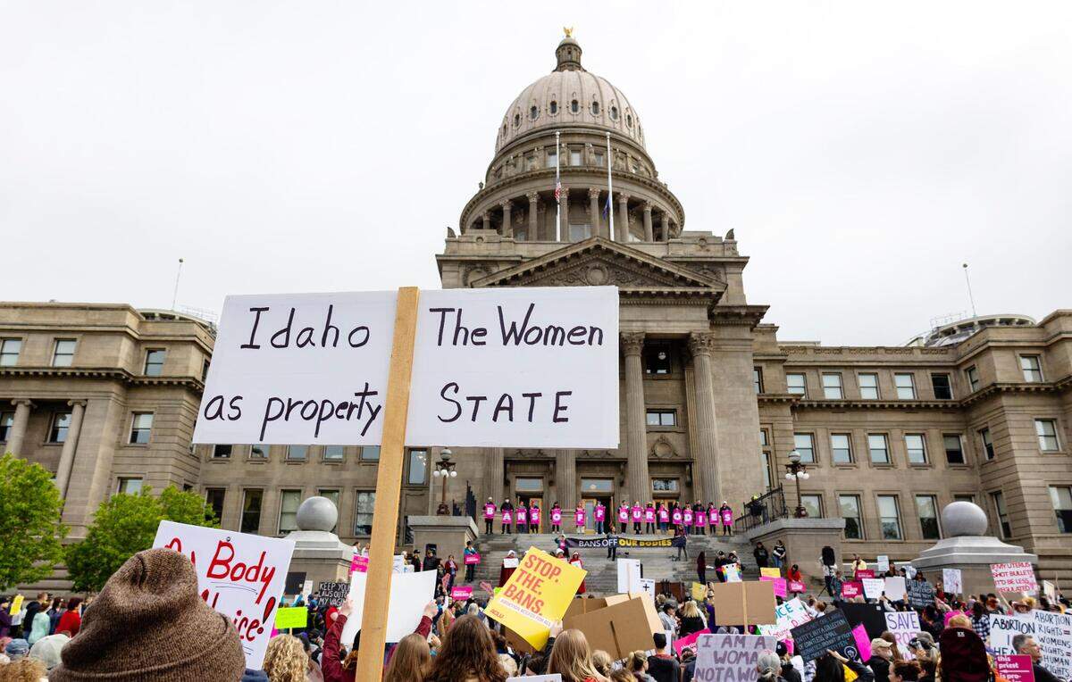 An attendee at Planned Parenthood’s Bans Off Our Bodies rally for abortion rights holds a sign reading “Idaho the women as property state” outside of the Idaho Statehous in May 2022.
