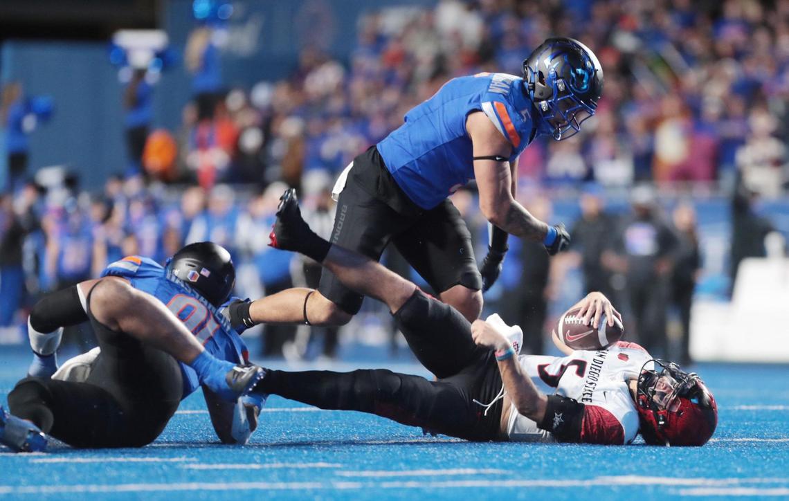 Boise State edge Jayden Virgin-Morgan (top) and defensive end Ahmed Hassanein (left) sack San Diego State wide quarterback Danny O’Neil during the second half. Boise State defeated San Diego State 56-24 at Albertson’s Stadium in Boise, Idaho.