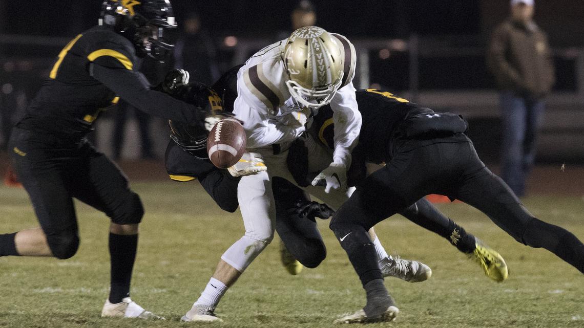 Bishop Kelly’s Matt Heilman, right, forces the ball loose from Vallivue’s Grant Garner and recovers the fumble in the third quarter of a 4A state semifinal game Friday at Bishop Kelly High.