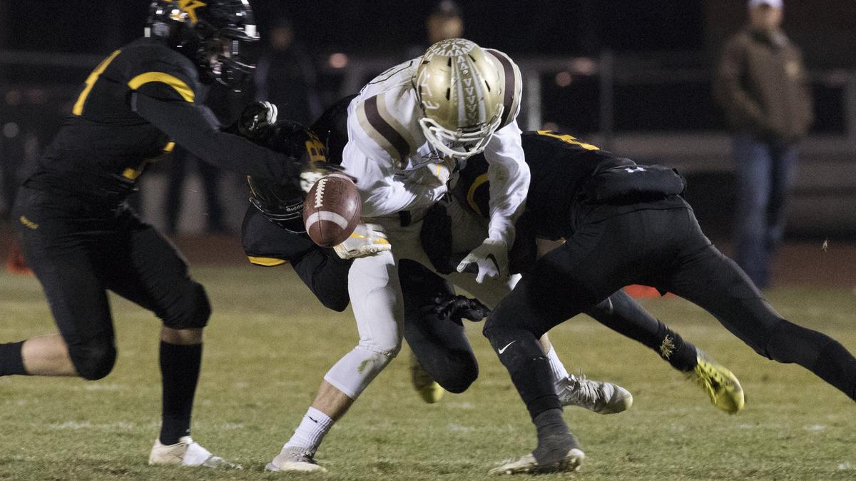 Bishop Kelly’s Matt Heilman, right, forces the ball loose from Vallivue’s Grant Garner and recovers the fumble in the third quarter of a 4A state semifinal game Friday at Bishop Kelly High.