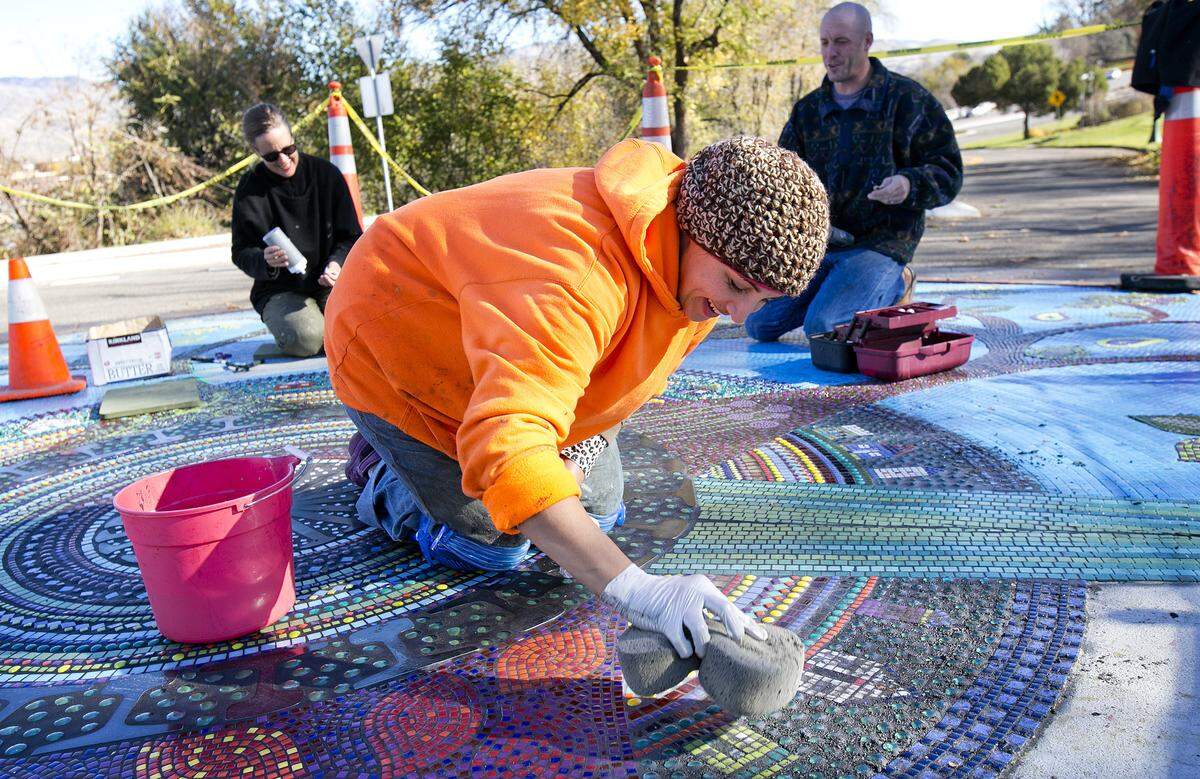 Reham Aarti, front, Anna Webb, back left, and Jeremy Pearson work on a public art mosaic called "Infernum Bestiae" on Crescent Rim Drive near the Boise Depot in November 2013. The artists would have used more-durable tiles had the neighborhood association been able to pay more for the work, Aarti said.