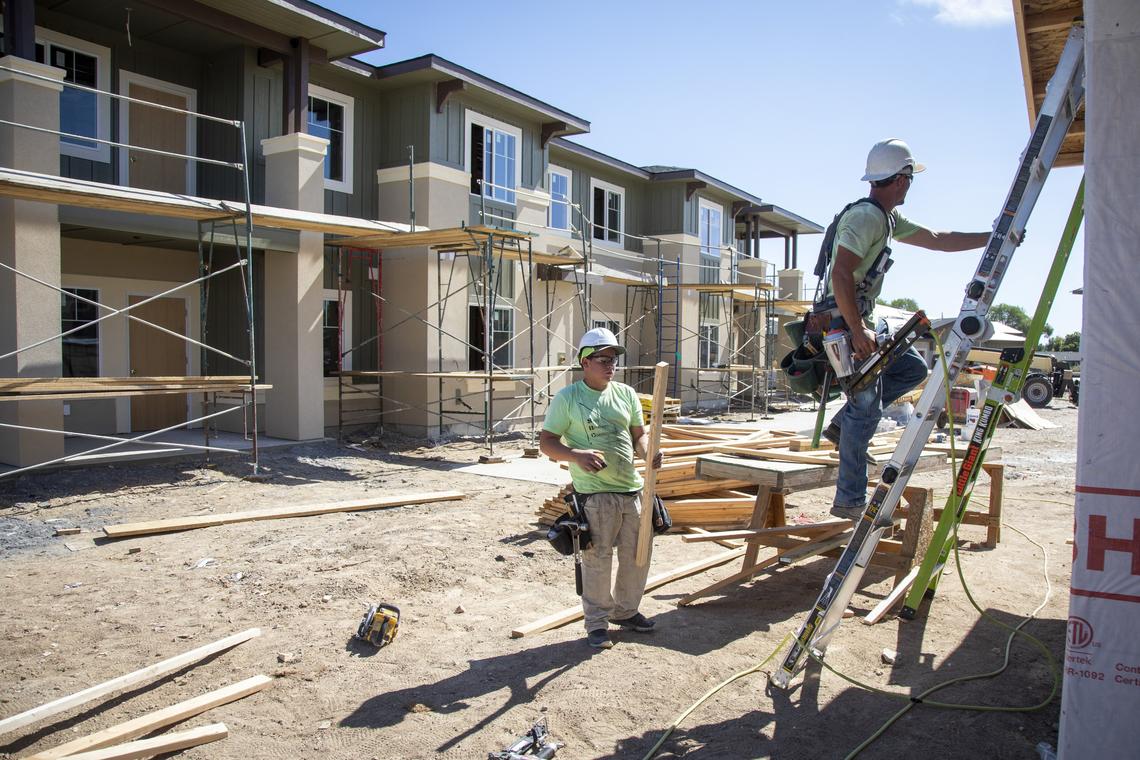 Construction apprentice Zephaniah Sevy, center, and framer William Sevy work on garages at The Villas at 12 Oaks in Meridian. 