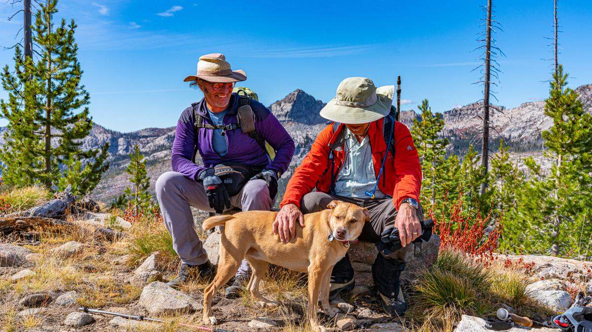 John Platt, left, sits at the top of a peak with his dog, Ruby, and friend Tom Lopez on Sept. 23, 2021. Platt and his friends referred to this peak as “65ish,” because Platt climbed it on his 65th birthday in 2020. It was also his “65th-ish” peak of 2021, friend Dave Beck said.