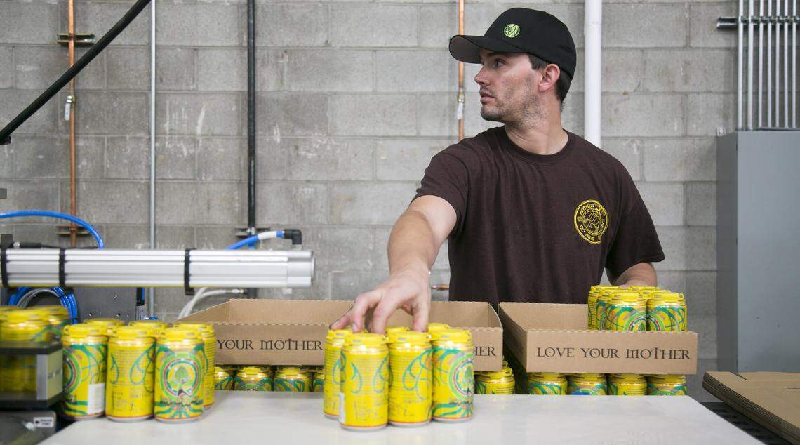 In Nampa, Mother Earth Brew Co. head brewer Chris Baker loads up a case of freshly canned Hop Diggity Double IPA.