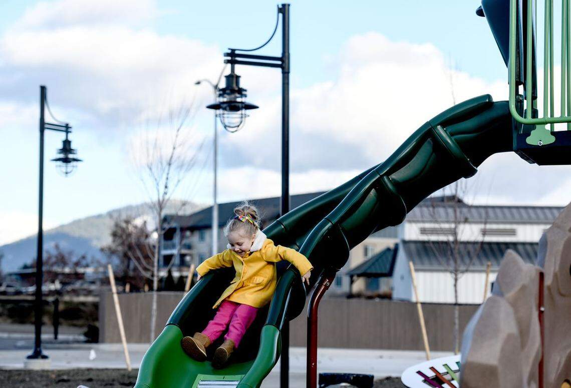 Five-year-old Emmy Colb makes use of a slide in the new park at the Atlas Waterfront Project near downtown Coeur d’Alene on Dec. 1, 2020. The land was the former Stimson Mill site. (Kathy Plonka/The Spokesman-Review)
