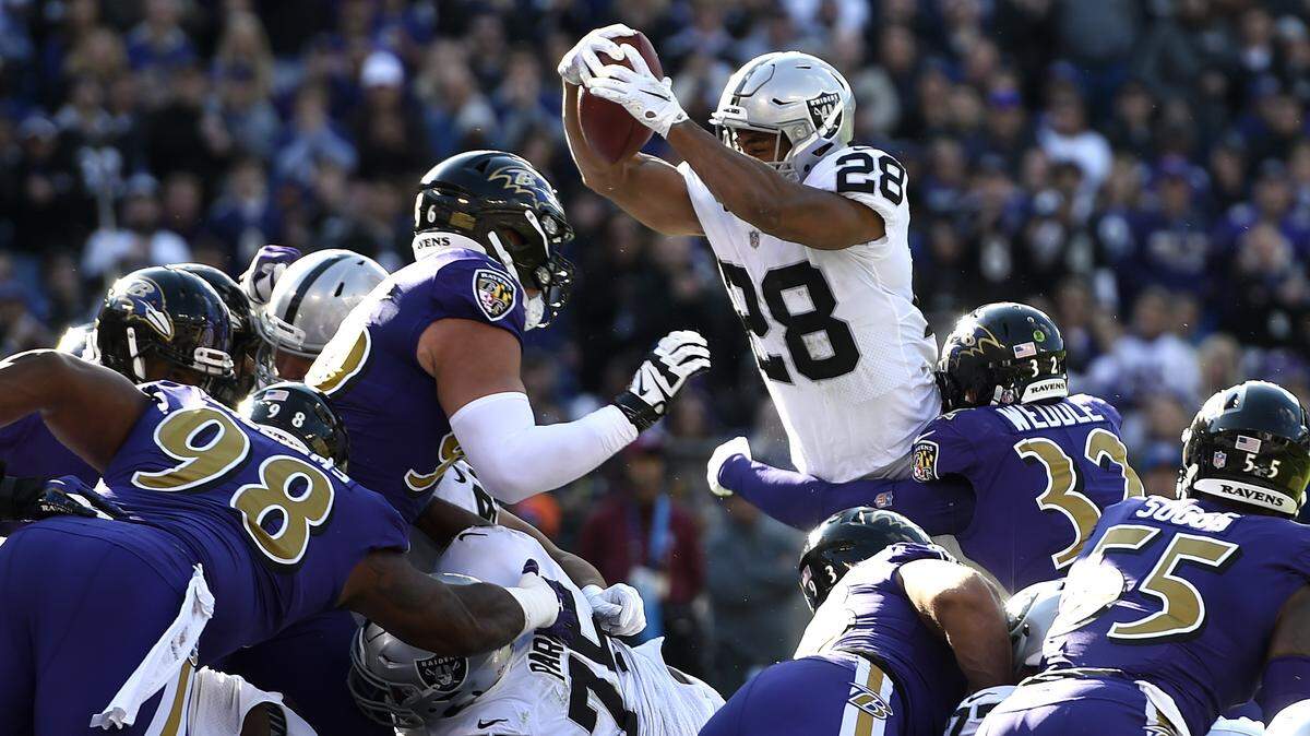 Oakland Raiders running back Doug Martin pushes into the end zone for a touchdown in the first half against the Baltimore Ravens on Nov. 25 in Baltimore.