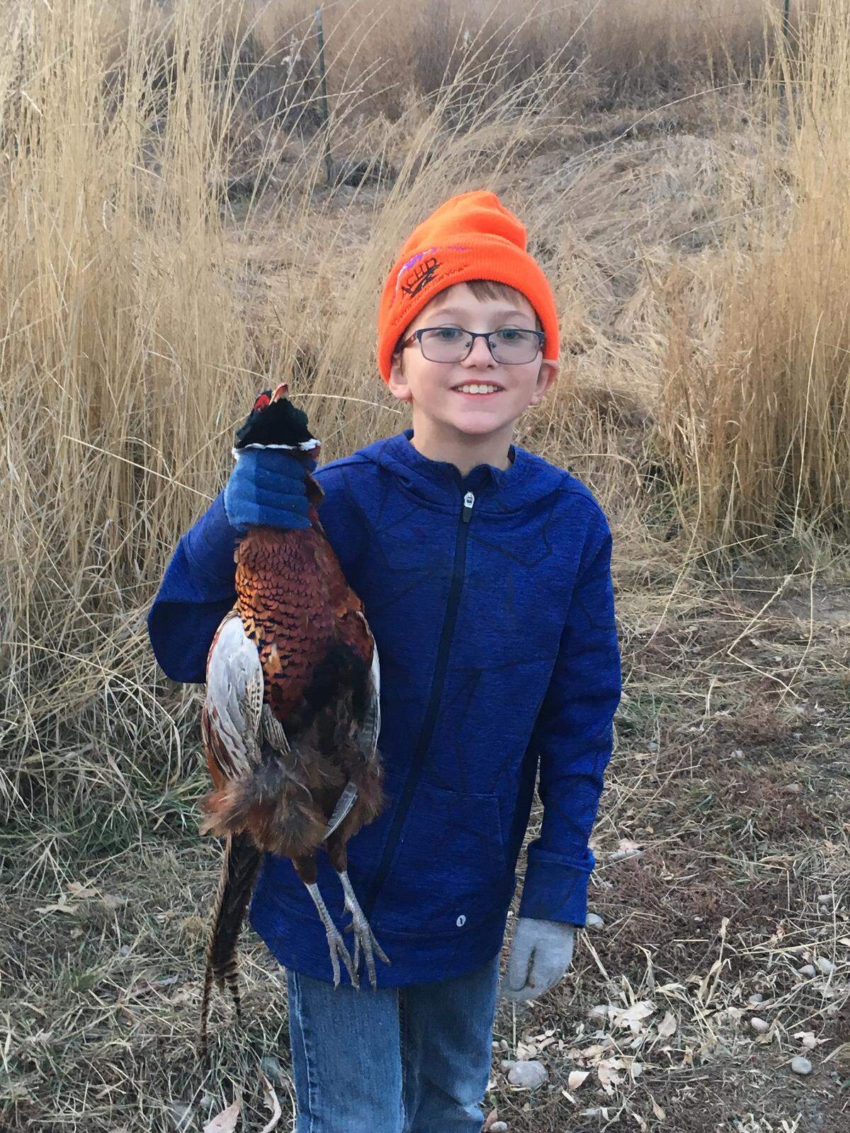 Rocky Barker’s grandson Linkon shows off a pheasant he retrieved. Linkon’s dad, Dan, shot the bird, and the family later prepared it with mushrooms and wine sauce.