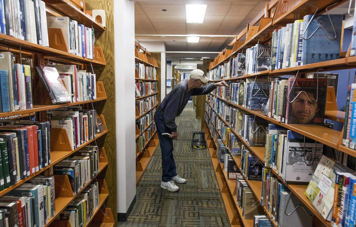 Jim Sprouls, Boise, browses for books about the Titanic at the public library in downtown Boise. Boise’s libraries are city-run and will fall under the purview of a new state law on hiring and firing authority over library directors.