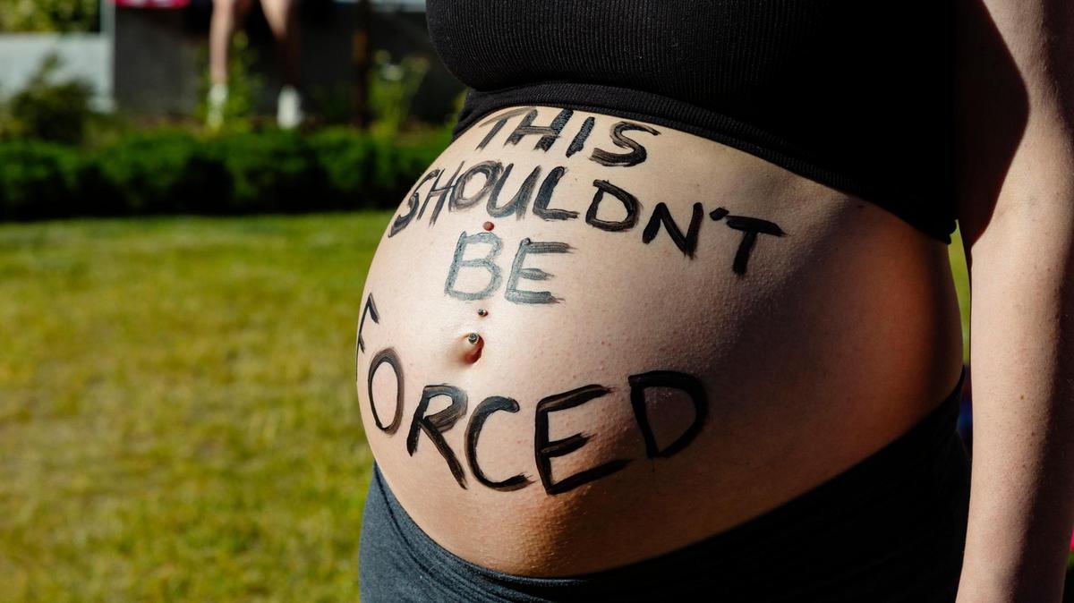 Megan Ewins shows off a message on her exposed pregnant belly that reads, “This shouldn’t be forced” during a 2022 rally in favor of abortion rights. The 9th Circuit Court of Appeals ruled Wednesday in one of several lawsuits challenging Idaho’s abortion bans.