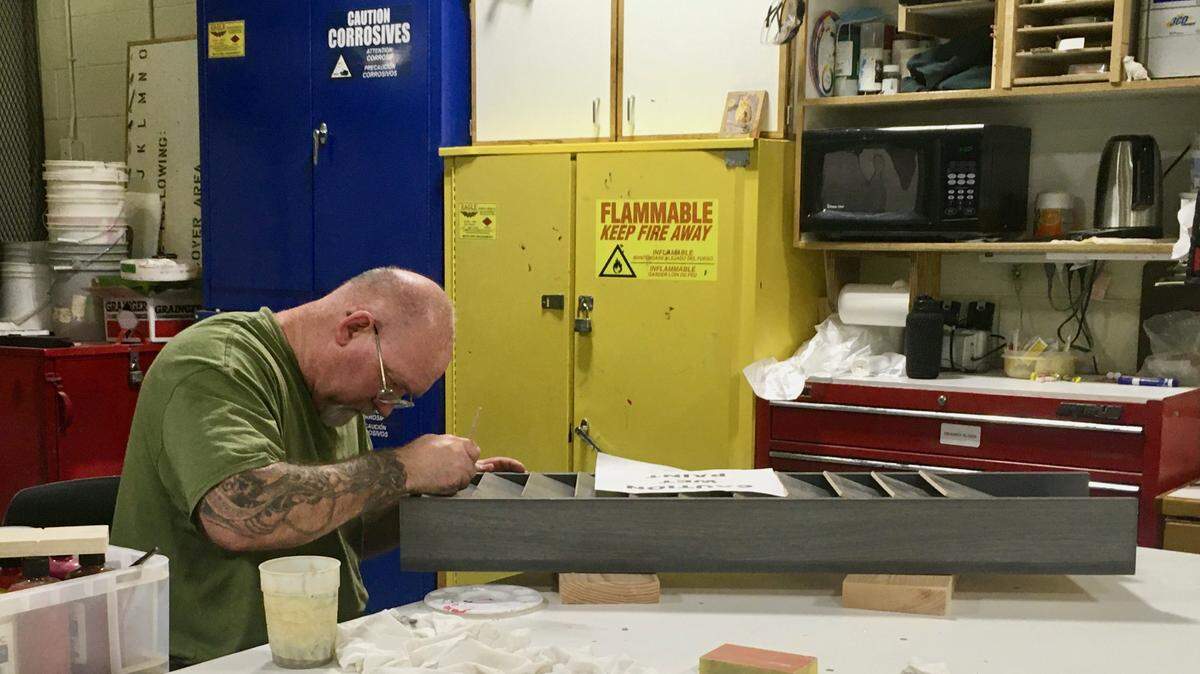 Richard Klipfel touches up a file rack in the Idaho State Correctional Center masonry and carpentry room. He completed the classroom component of a carpentry apprenticeship at the Idaho Maximum Security Institution and is now working as a teaching assistant as well as on projects.