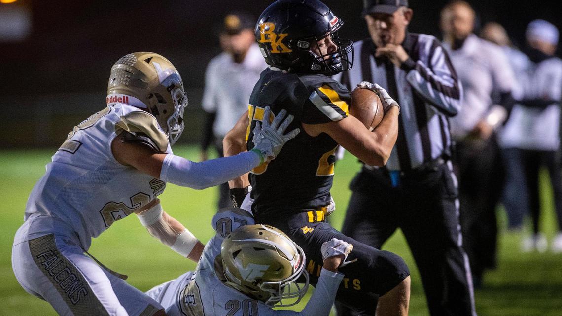 Bishop Kelly’s Seth Knothe fights through a tackle from Vallivue’s Eliaez Baez (20) and Braxdon Bailey during the Knights’ 35-12 win on Friday.