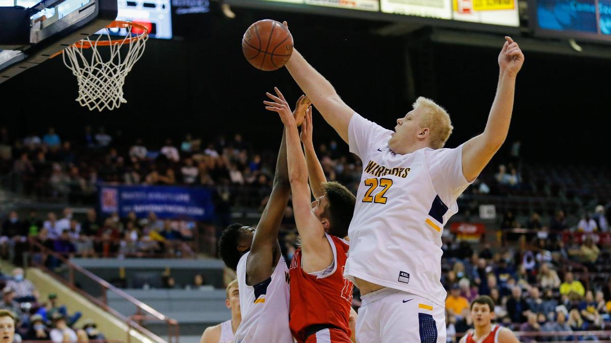 Meridian senior Brody Rowbury blocks the shot of Madison’s Taden King in the 5A boys basketball state semifinals Friday at the Ford Idaho Center in Nampa.