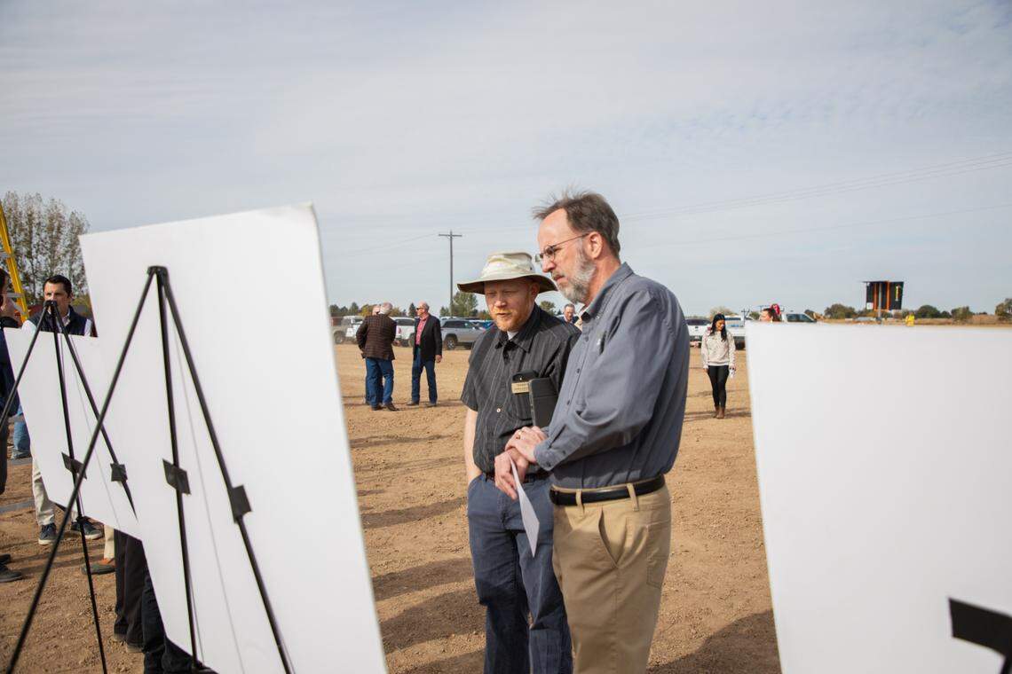 Ada County Highway District Commissioner Dave McKinney, right, examines construction plans for the Ustick Road, State Highway 16 expansion at Tuesday’s groundbreaking.
