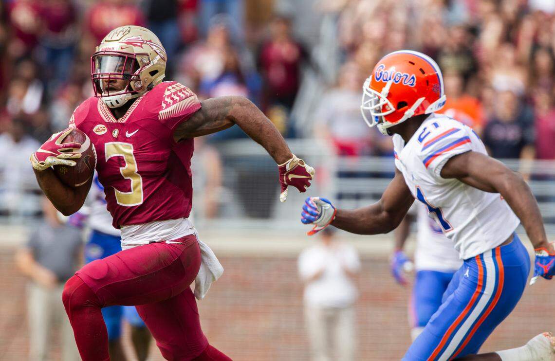Florida State running back Cam Akers, left, makes a long reception and run past Florida defensive back Trey Dean III in the first half of their game Nov. 24, 2018, in Tallahassee, Fla.