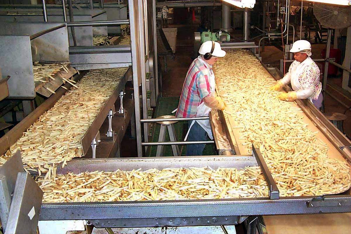 Workers at a J.R. Simplot Co. factory sort french fires. The Boise company expects to take over operation of Ore-Ida’s plant in Ontario later this year.