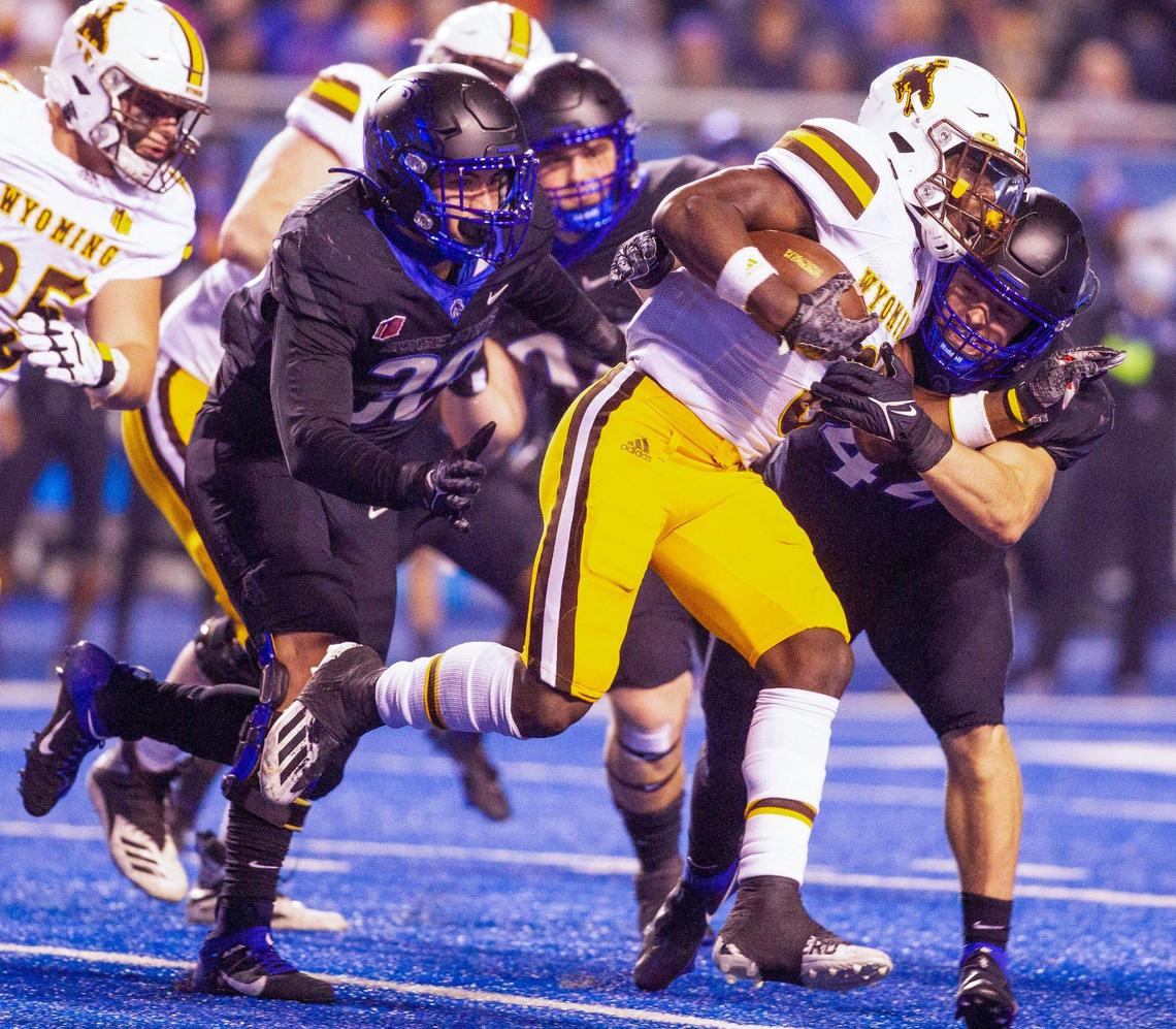 Boise State linebacker Riley Whimpey tackles Wyoming running back Titus Swen as other Broncos close in during second-half action at Albertsons Stadium.