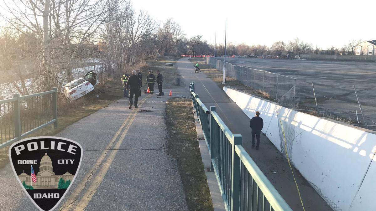 First responders work the scene of a crash after a car left Main Street and crashed on the Boise Greenbelt on Wednesday evening.