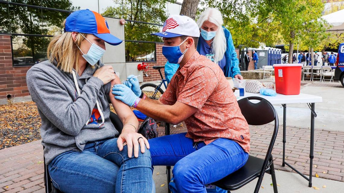 Shalyn Blaisdell, of Kuna, receives a dose of COVID-19 vaccine from Boise State nursing program student Dane Larson outside Albertsons Stadium on Sept. 18. Boise State rewarded fans with prizes for being vaccinated and masking up.