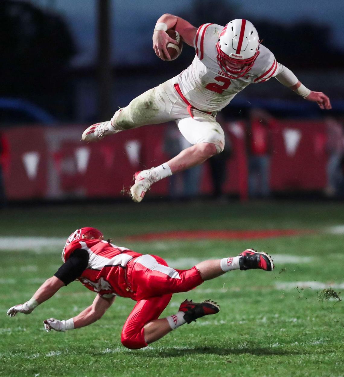 Weiser quarterback Brett Spencer leaps over Homedale’s Eli Heck last week. Homedale has already clinched the 3A SRV title, and Weiser has clinched a 3A playoff berth.