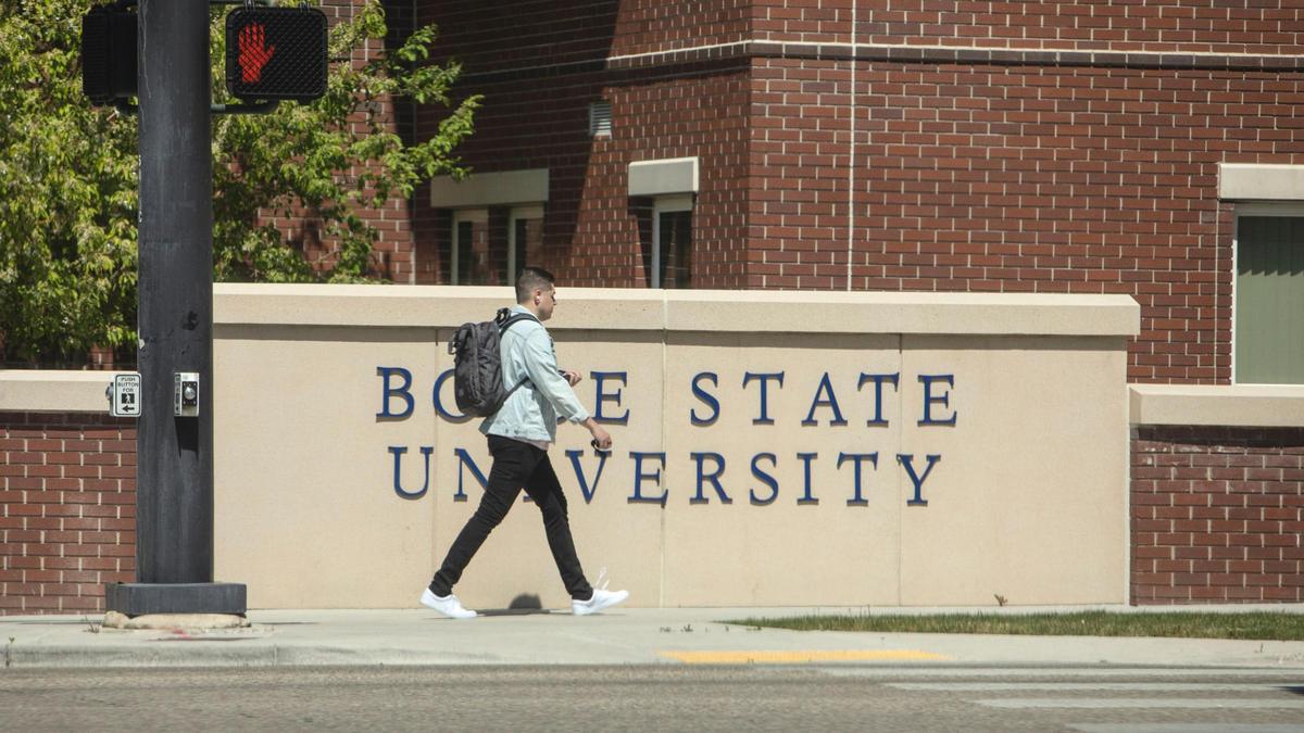 As part of a pilot, Boise State students will design programming on issues such as access to, and retention and equity in, higher education. A student uses a the sidewalk on campus in April.