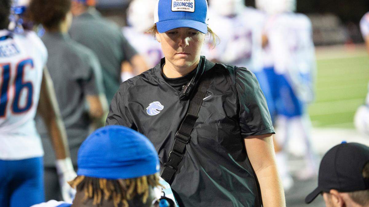 McKenna Drevno, the assistant athletic trainer for the Boise State football team, speaks with a player and coach during their game at New Mexico earlier this month.