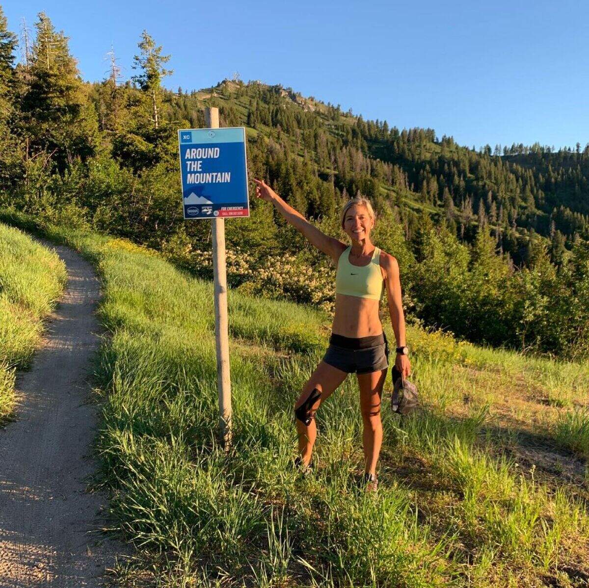 Alyssa Rogers, of Boise, poses with the Around the Mountain Trail sign at Bogus Basin. Rogers was the first person to finish the Boise Trails Challenge on foot this year, running roughly 45 miles per day for five consecutive days.