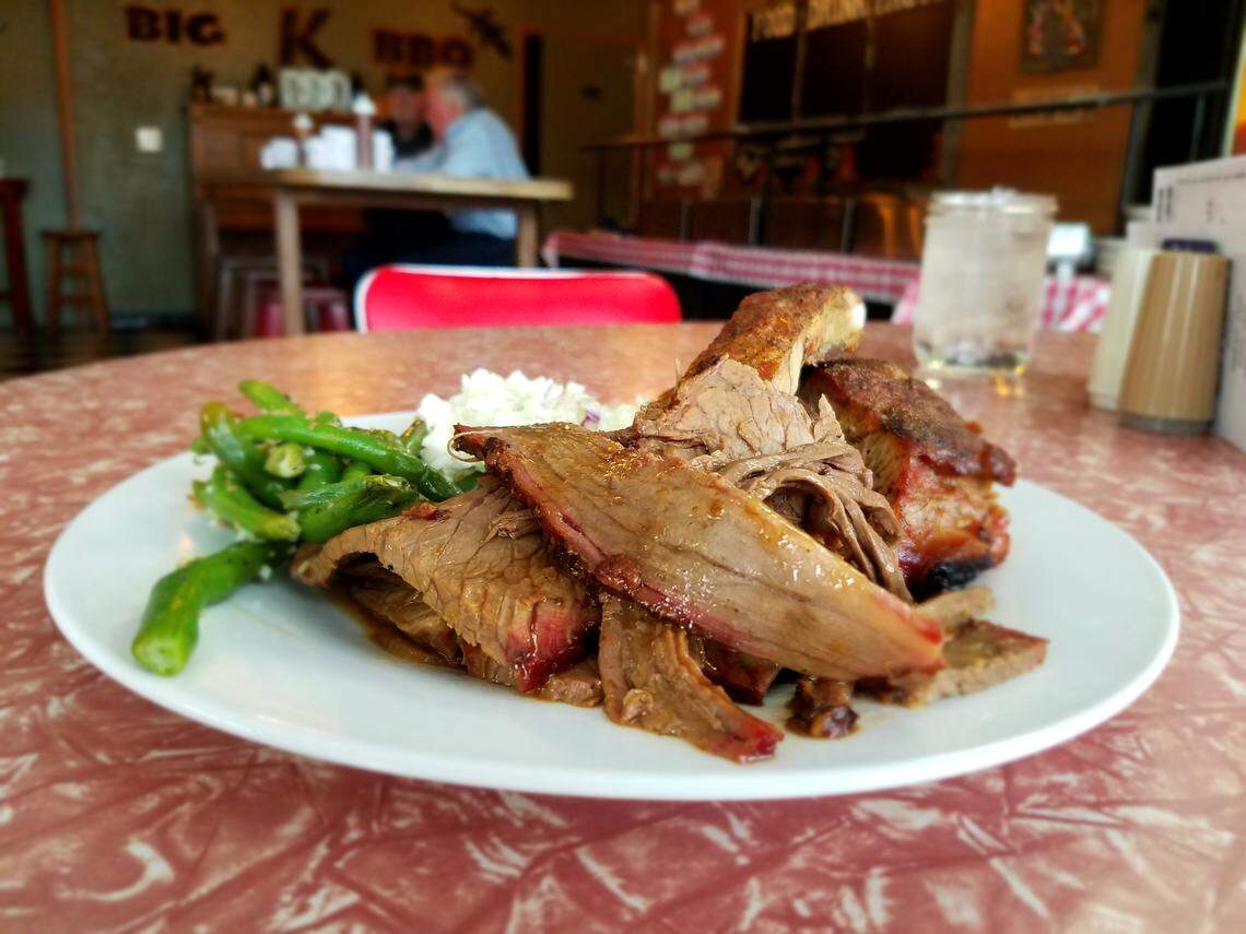 Clockwise from front: Brisket, garlic-bacon green beans, coleslaw and ribs dished up from the lunch buffet at Big K BBQ in Garden City.