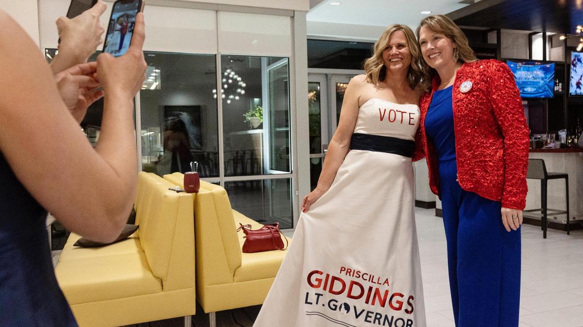 Kirsten Lucas wears a dress advertising voting for Priscilla Giddings for lieutenant governor while posing for a photo Tuesday with the Republican candidate in the lobby of the Hilton Garden Inn Boise Downtown. Giddings and several other far-right candidates were popular with Canyon County voters.