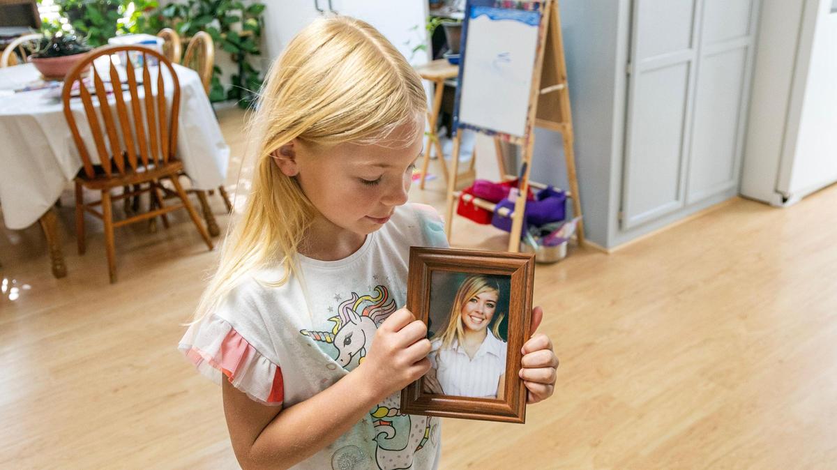 Aleiah, 8, holds an old photograph of her mother Kellei Bunn. Kellei Bunn died after she was seriously injured in a crash on July 4.