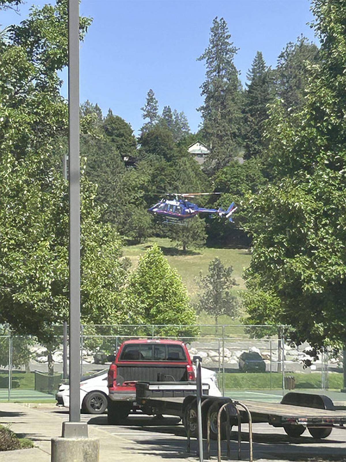 A helicopter lands at Cherry Hill Park on Sunday afternoon, following reports of an ambush attack on firefighters called to a brush fire on Canfield Mountain.