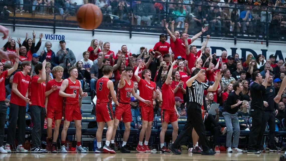 Owyhee’s bench celebrates a 3-pointer against Eagle in the 5A District Three boys basketball championship Friday at Meridian High School. The Storm won the title game 71-49.