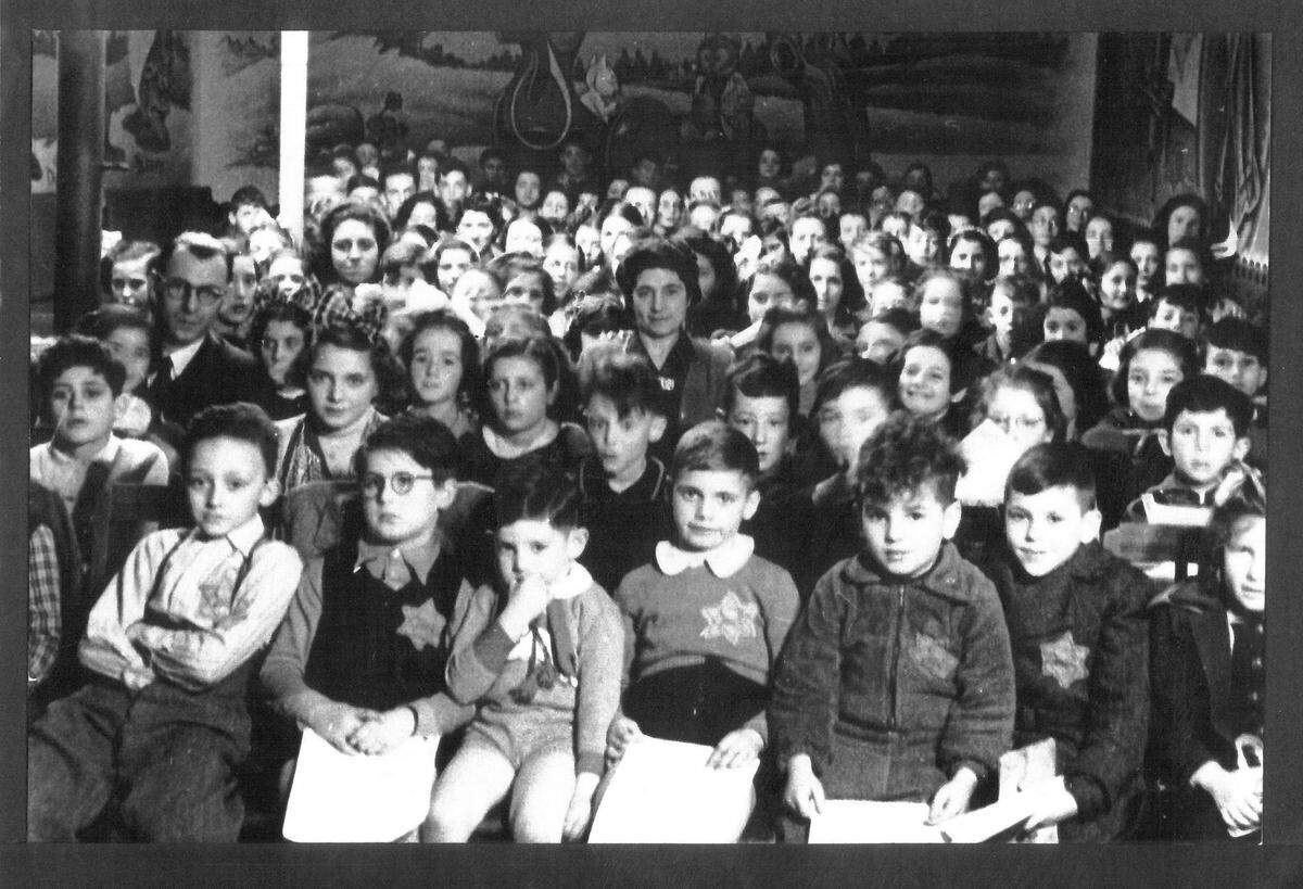 This photo shows Pete Metzelaar, front row, center, with his classmates in Amsterdam around 1941, before Metzelaar and his mother went into hiding at a small farm in the countryside.