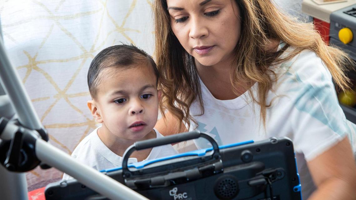 Jessica Mandujano ayuda a su hijo Joaquín, de 5 años, a aprender a usar un dispositivo que rastrea el movimiento de sus ojos para interactuar con aplicaciones en la pantalla. Le han diagnosticado el síndrome de Emanuel, un trastorno cromosómico raro que limita el desarrollo infantil en múltiples niveles. Ella espera que el dispositivo le ayude a Joaquín a aprender a comunicarse, ya que la mayoría de las personas con síndrome de Emanuel no son verbales. Los maestros de su escuela de desarrollo aún no se han entrenado con él en el dispositivo, que Jessica dijo que acababan de adquirir cuando se inició la pandemia del coronavirus.