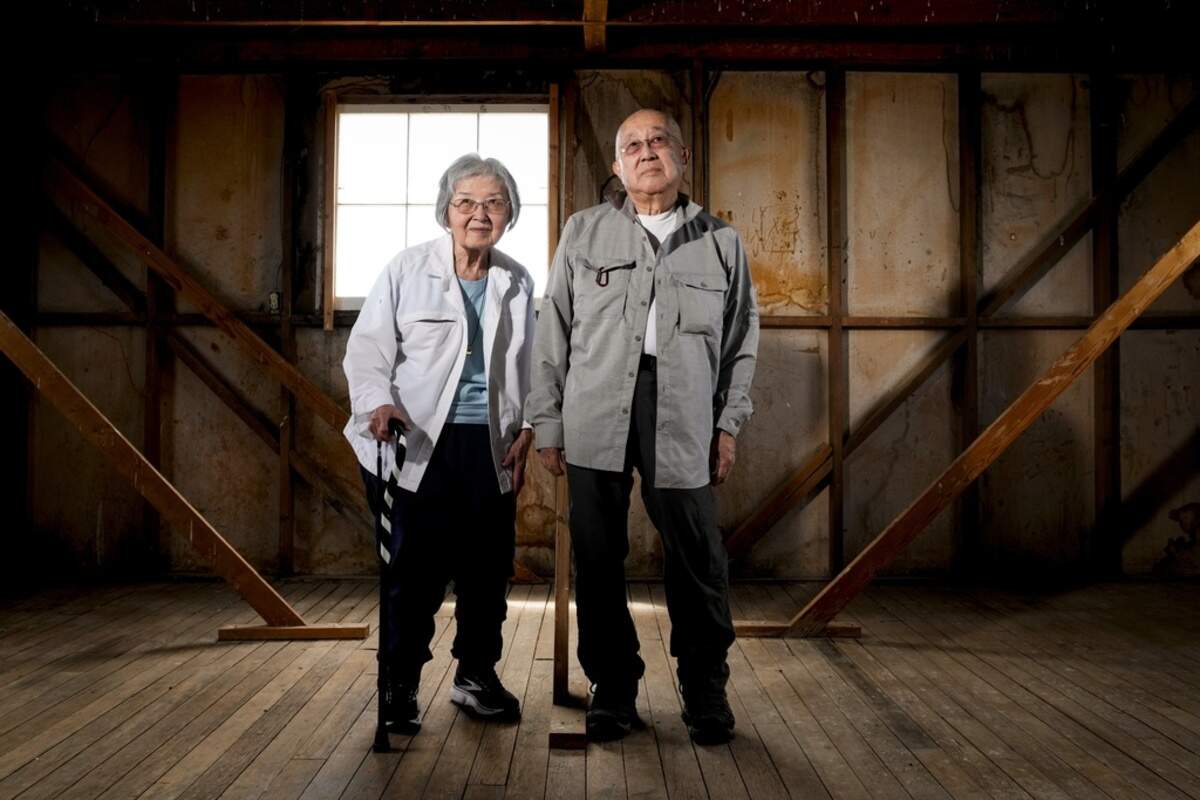 Minidoka survivor Paul Tomita, right, poses for a photograph with his wife, Mabel Imai Tomita, a Gila River and Tule Lake survivor, in an original barracks at Minidoka.