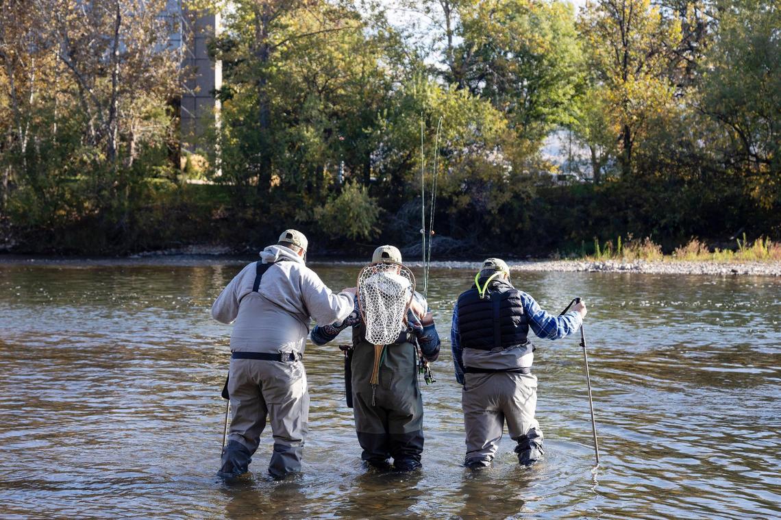 Russell Massey of Nampa, left, volunteer José Karry of Boise, center, and Richard Seltzer of Caldwell, right, carefully walk into the Boise River together during a day retreat for Idaho2Fly on Oct. 9, 2021. It was Massey and Seltzer’s first time fly fishing. Idaho2Fly is a nonprofit that helps men with cancer connect with one another through fly fishing together.
