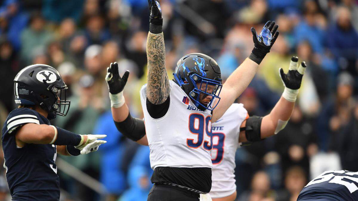 Boise State defensive lineman Scott Matlock signals touchdown on a play where he was a blocker on offense in the team’s win over BYU.