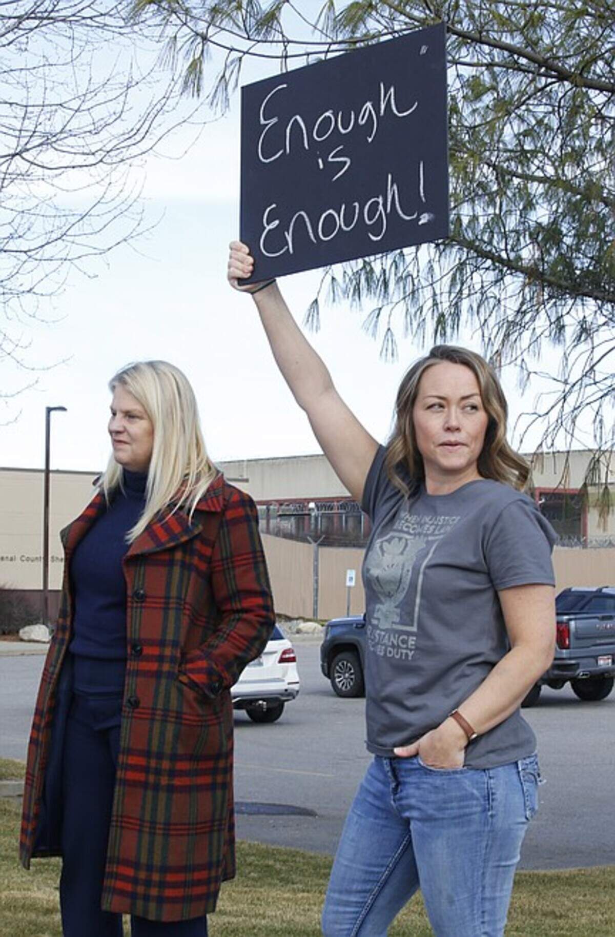 Sarah Martin, right, holds aloft a protest sign Friday.