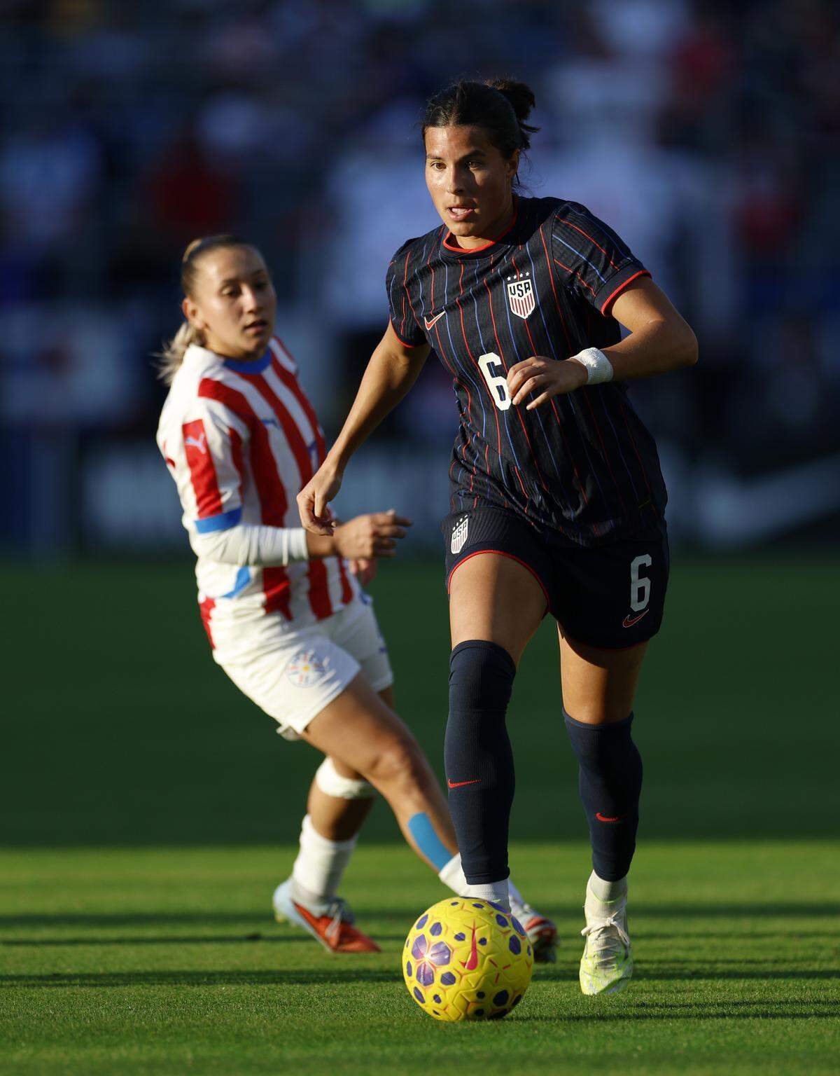 CARSON, CALIFORNIA - JANUARY 24: Emily Sams #6 of United States dribbles away from Maria Tamay #7 of Paraguay during an international friendly between Paraguay and The United States at Dignity Health Sports Park on January 24, 2026 in Carson, California. (Photo by Harry How/Getty Images)