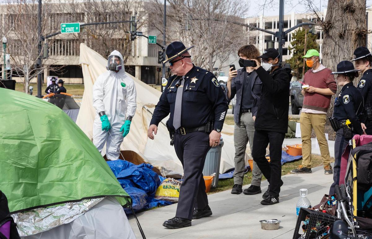 Supporters of the downtown Boise homeless protest called Operation Hope record videos of an Idaho State Police officer as a private company works to remove tents and other items deemed hazardous waste from the demonstration site on Friday. ISP was on scene providing safety and security and did not take any enforcement action.