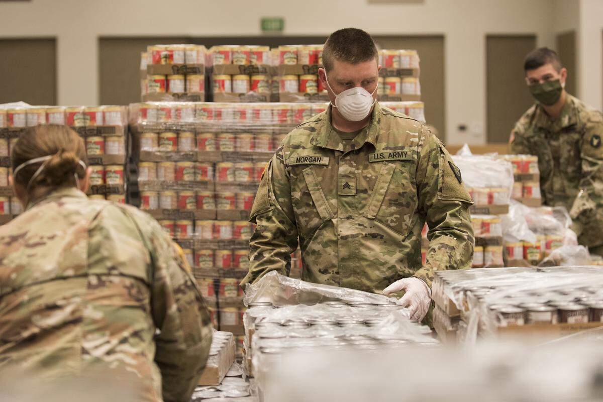 Sgt. Eli Morgan, of Emmett, and other citizen soldiers from the Idaho National Guard assist employees of the Idaho Foodbank and volunteers from Idaho’s Dairy West at the Boise Centre to build food boxes for Idaho students in need on April 8.