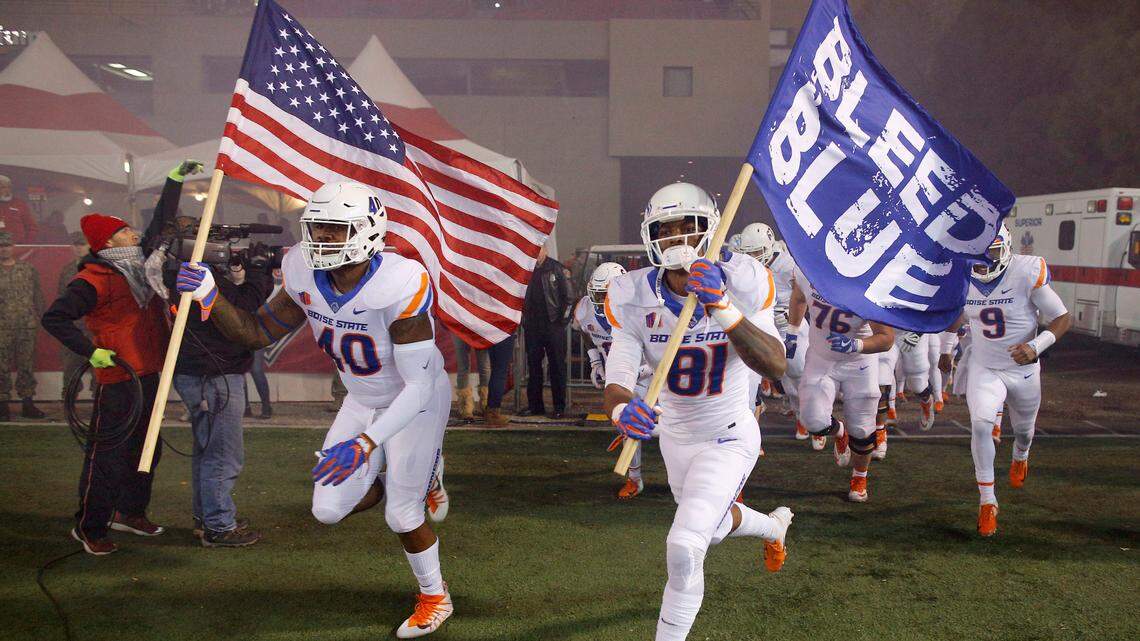 Boise State defensive tackle Jabari Watson (40) and wide receiver Akilian Butler (81) lead their team while taking the field to face New Mexico on Friday Albuquerque, N.M.